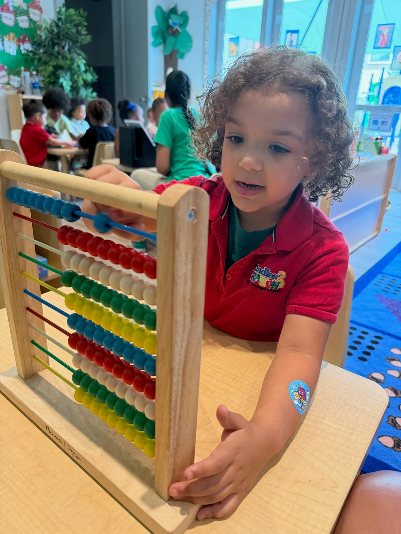 Child exploring an abacus in the classroom